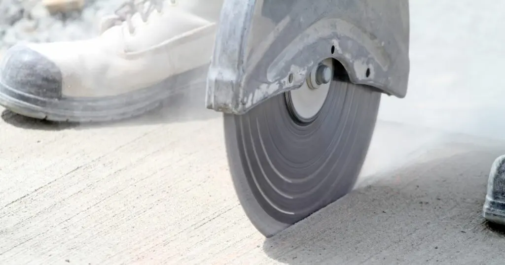 Angle grinder cutting concrete with a diamond blade