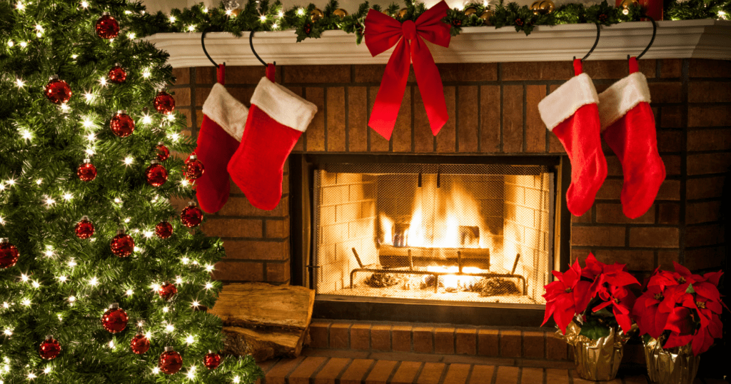 Christmas living room with decorated tree, fireplace, red stockings, and poinsettias