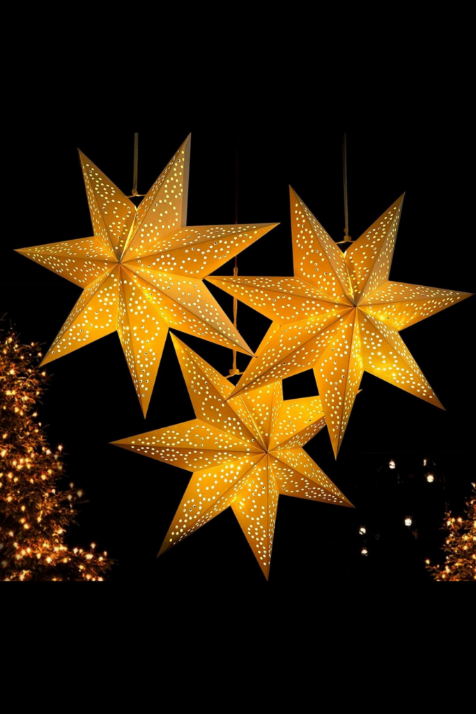 Christmas church stage decorated with star-shaped lanterns hanging above and festive holiday decorations.