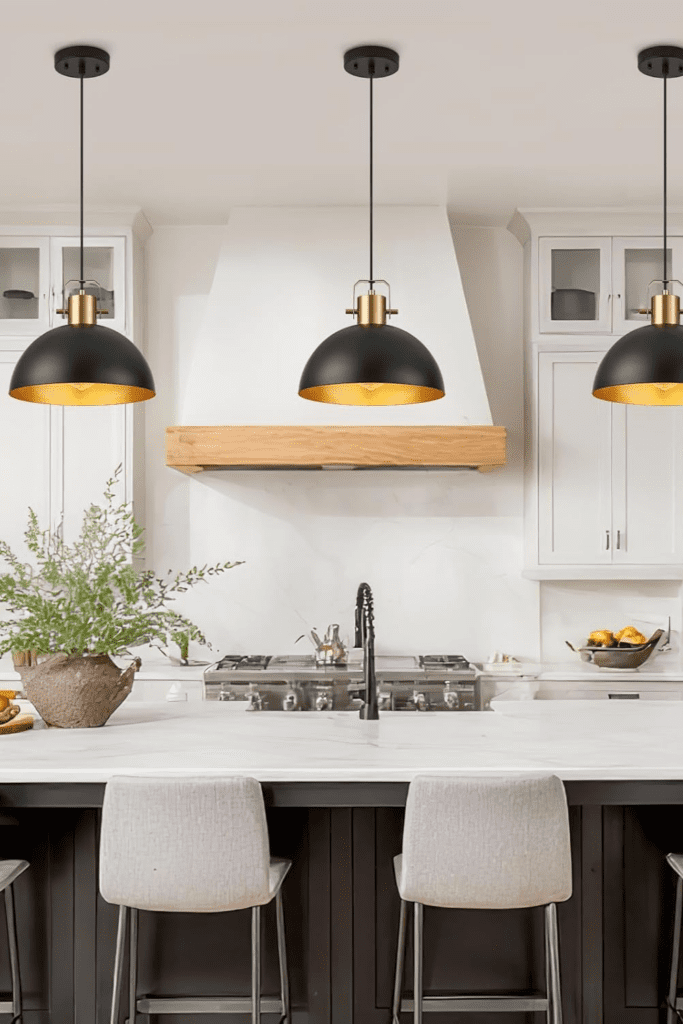 A kitchen sink or breakfast bar with three small pendant lights hanging above it, illuminating the countertop.