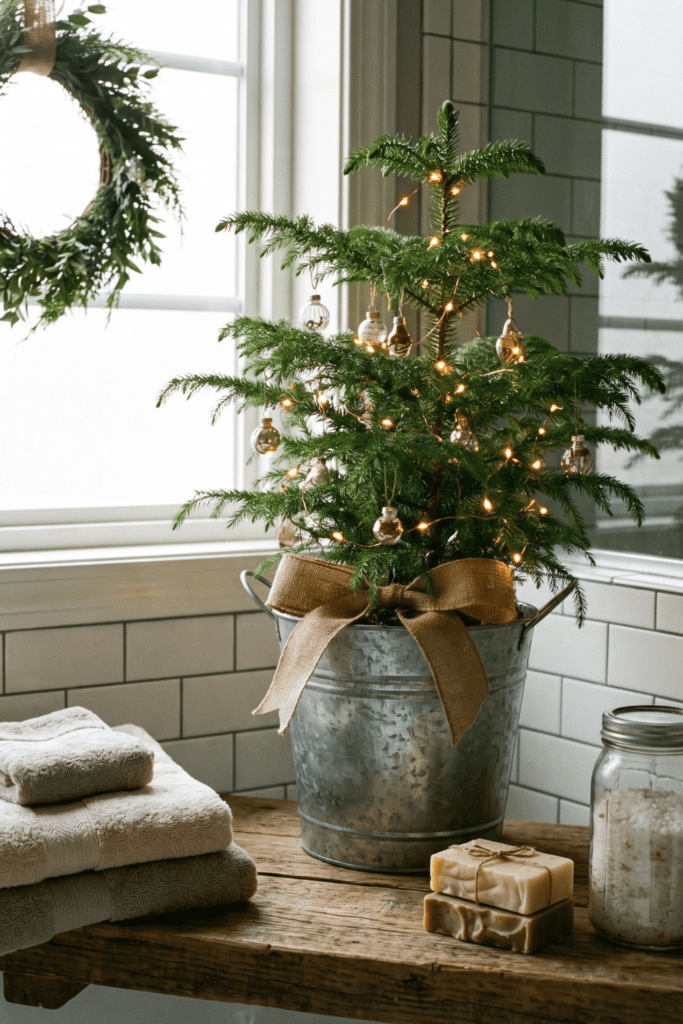 A small Norfolk pine tree in a galvanized metal bucket decorates a bathroom shelf for Christmas.